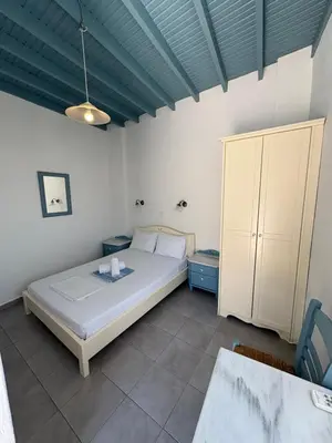 a bedroom with a white bed and a blue ceiling at Sofia Rooms in Loutro