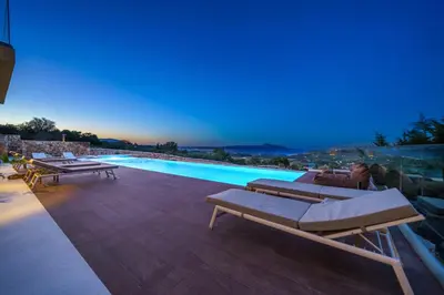 a villa with a swimming pool at night at In Vivo Villa - Breathtaking View -90sqm Heated Infinity Pool in Áyios Pávlos
