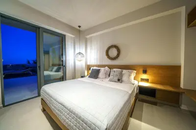 a bedroom with a white bed and a large window at In Vivo Villa - Breathtaking View -90sqm Heated Infinity Pool in Áyios Pávlos