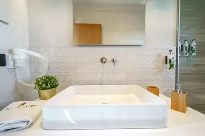a white sink in a bathroom with a shower at In Vivo Villa - Breathtaking View -90sqm Heated Infinity Pool in Áyios Pávlos