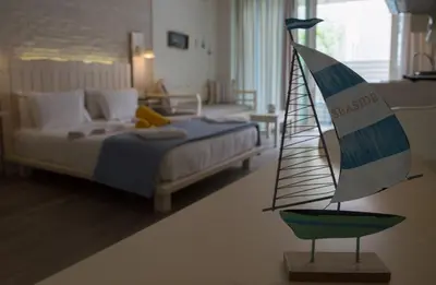 a toy sailboat on a table in a bedroom at Alkionides Seaside Hotel in Plataniás