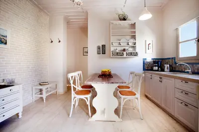 a kitchen with a table and chairs and a sink at Alkionides Seaside Hotel in Plataniás