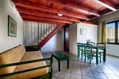 a living room with a couch and a table and chairs at Alkionides Seaside Hotel in Plataniás