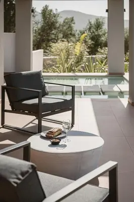 a table with a glass of wine and a plate of food at Villa Aora Falassarna Beach I New luxury villa with infinity pool in Falasarna