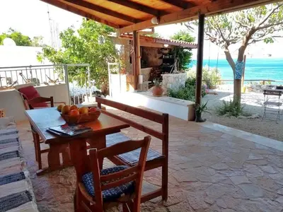 a table and chairs on a patio with a view of the ocean at 2 annexed apartments -Private place to swim-large terrace- Unlimited view in Ravdhoúkha