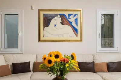 a living room with a couch with a vase of flowers at Villa Ithaca in Varípetron
