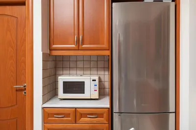 a kitchen with a stainless steel refrigerator and wooden cabinets at Villa Ithaca in Varípetron