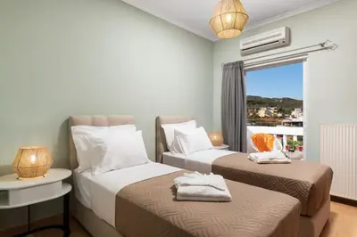 a hotel room with two beds and a window at Villa Ithaca in Varípetron