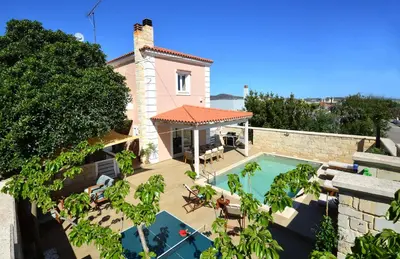 an external view of a house with a swimming pool at Villa Ithaca in Varípetron