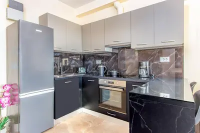 a kitchen with white cabinets and black appliances at Nikolas City Home in Chania Town