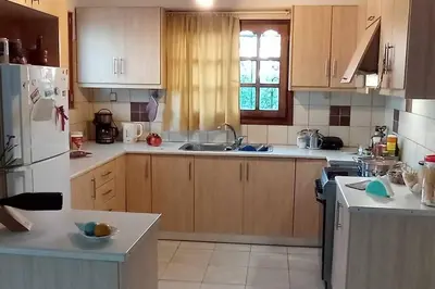 a kitchen with wooden cabinets and a white refrigerator at Spacious Sunny house in Chania in Chania Town