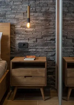 a bedroom with a nightstand and a brick wall at Casa 28 City Apartments in Chania Town