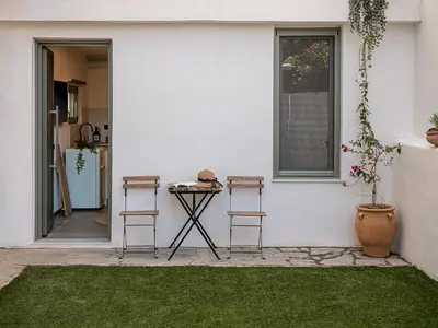 a patio with two chairs and a table in front of a house at Casa 28 City Apartments in Chania Town
