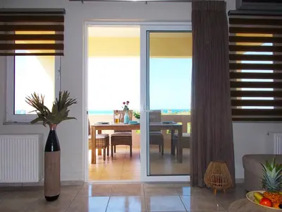 a living room with a table and a dining room at Stelia Apartment Gerani in Ayiá