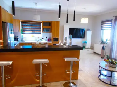 a kitchen with a large island with bar stools at Stelia Apartment Gerani in Ayiá