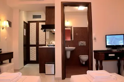 a bathroom with a toilet and a sink and a television at Corali Studios in Palaiochóra