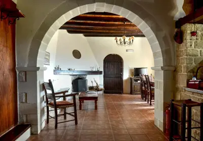 an archway in a living room with a table and chairs at Anemole Traditional Cretan Villa in Megála Khoráfia