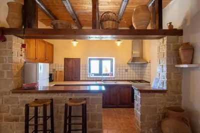 a kitchen with a counter with stools in it at Anemole Traditional Cretan Villa in Megála Khoráfia