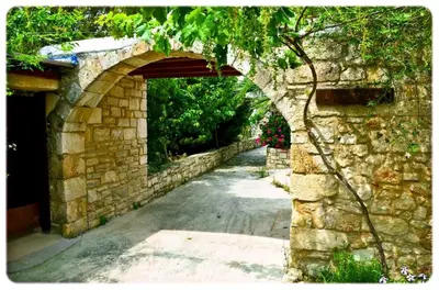 an archway in a stone wall next to a road at Anemole Traditional Cretan Villa in Megála Khoráfia