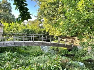 a bridge over a river in a park at Villa Ovgoro, Provarma, pool, seaview balcony in Próvarma