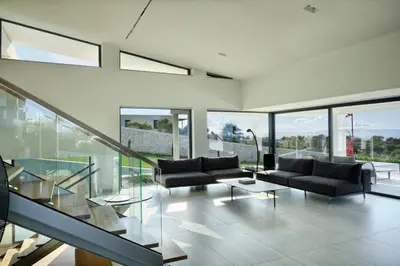 a living room with two couches and a glass staircase at Villa St John - Wellness & Entertainment by etouri in Chania Town