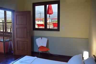a bedroom with a bed and a window and a chair at Venetian Cistern Villa in Kalamítsion Alexándrou