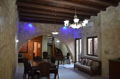 a dining room with a table and a stone wall at Venetian Cistern Villa in Kalamítsion Alexándrou