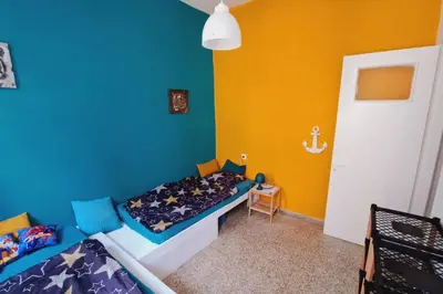 a bedroom with two beds and a blue and yellow wall at Beautiful house in the old town of Chania- 4 rooms in Chania Town