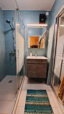 a bathroom with a sink and a shower and a mirror at Beautiful house in the old town of Chania- 4 rooms in Chania Town