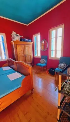 a room with a bed in a room with red walls at Beautiful house in the old town of Chania- 4 rooms in Chania Town