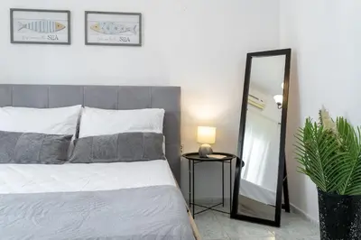 a bedroom with a bed and a mirror at Elie's House next to the beach in Chania Town