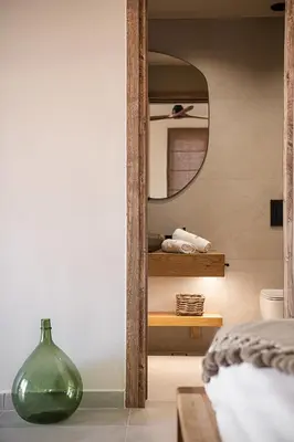 a bedroom with a green vase and a mirror at Nomada Chania Apartments in Chania Town