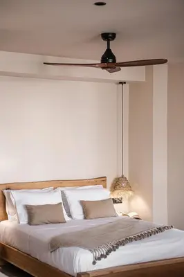 a bedroom with a large bed with a ceiling fan at Nomada Chania Apartments in Chania Town