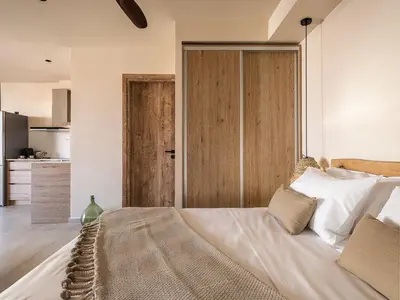 a bedroom with a large bed with a wooden door at Nomada Chania Apartments in Chania Town