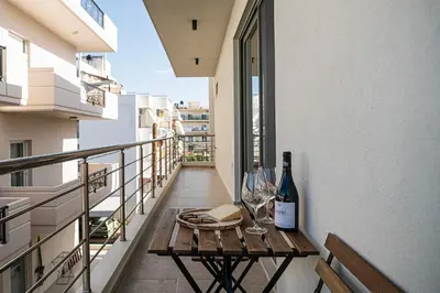 a balcony with a table with wine bottles and glasses at Nomada Chania Apartments in Chania Town