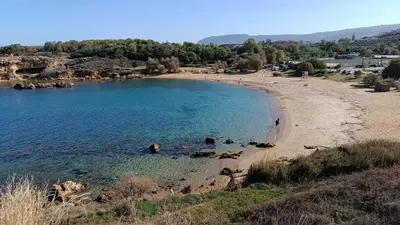 a beach with a group of people in the water at Villa Ammos in Daratso