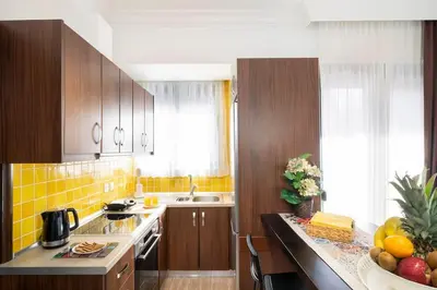 a kitchen with wooden cabinets and a counter with fruits on it at Home Philip III in Chania Town