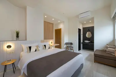 a bedroom with a large bed and a living room at Chrysa Apartments in Chania Town