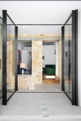 a room with a glass door with a green couch at Elorhouse in the charming neighborhood of KoumKapi in Chania Town