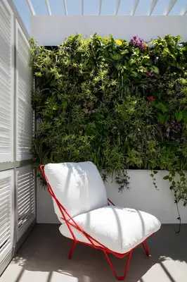 a red and white chair in front of a plant at Elorhouse in the charming neighborhood of KoumKapi in Chania Town