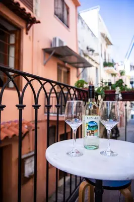 a bottle of wine sitting on a table with two wine glasses at Athena's House in Chania Town