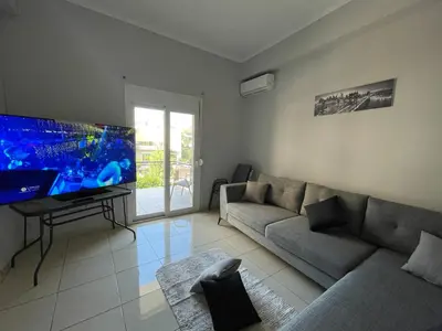 a living room with a couch and a flat screen tv at Jomaa luxury residence in Chania Town