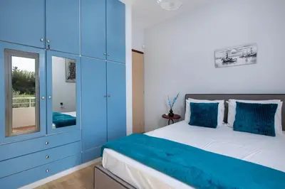 a blue bedroom with a bed with blue cabinets at Green Hill Villa in Daratso