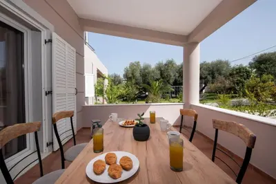 a table with two plates of food on a balcony at Green Hill Villa in Daratso