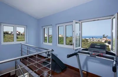 a room with windows and a treadmill and a balcony at Green Hill Villa in Daratso