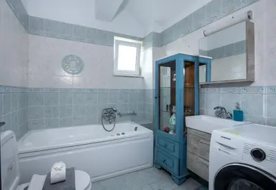 a bathroom with a tub and a toilet and a sink at Green Hill Villa in Daratso