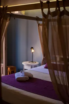 a bedroom with a bed with a canopy and a table at Elia Potie in Chania Town