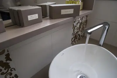 a bathroom with a white sink and boxes on a counter at Elia Potie in Chania Town