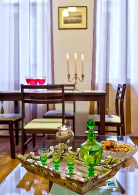 a dining room table with a green vase and candles at Aphrodite House in Chania Town