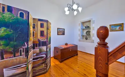 a living room with a staircase and a painting on the wall at Aphrodite House in Chania Town